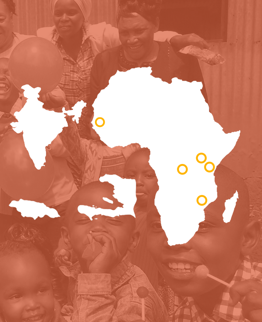A group of smiling children holding lollipops pose with two adults in the background. The image is overlaid with white and yellow map shapes. The overall photo has a warm orange tint.